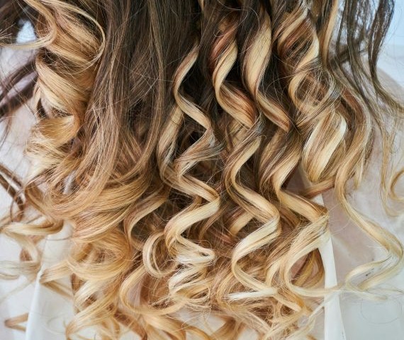 Obraz ukazuje włosy kobiety poddane trwałej ondulacji.